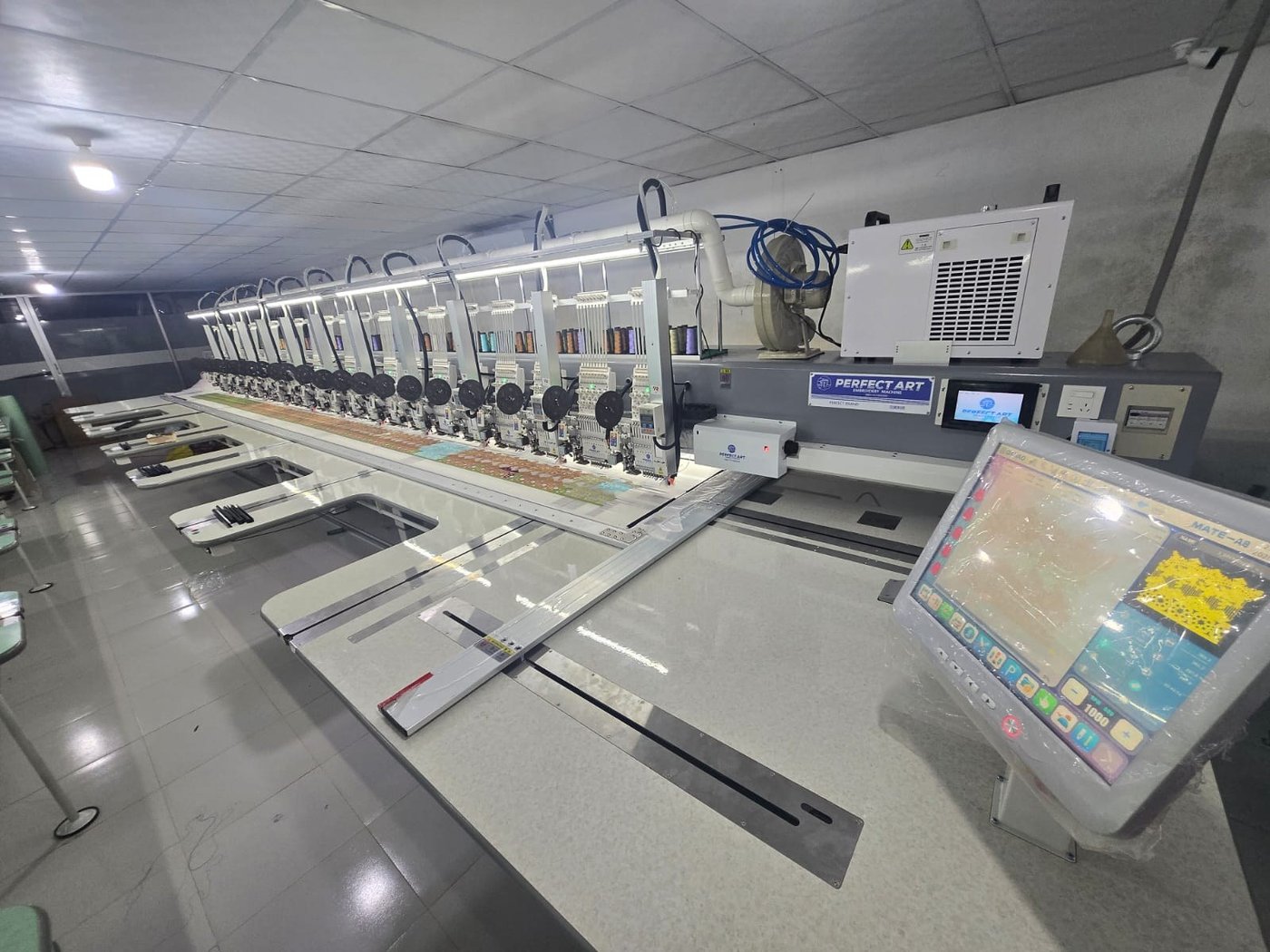 A row of Perfect Art multi-head embroidery machines in the workshop